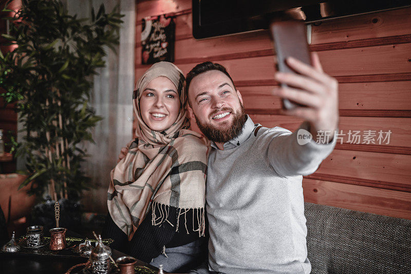 可爱微笑的穆斯林夫妇在咖啡时间自拍