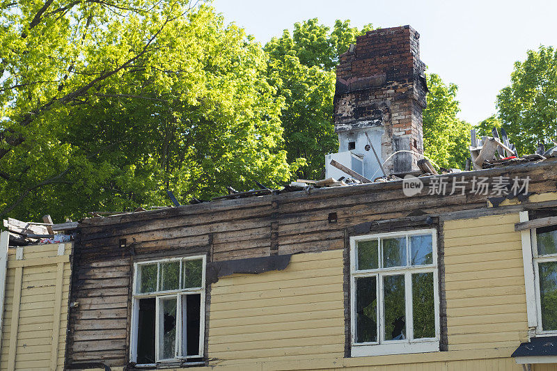 在芬兰的城市街道上，一座木头房子被大火烧毁，成为了一座建筑的废墟。