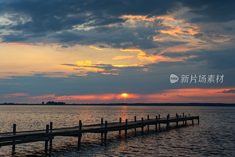 码头的剪影与壮丽的云景日落在湖施泰因胡德米尔，下萨克森州，德国