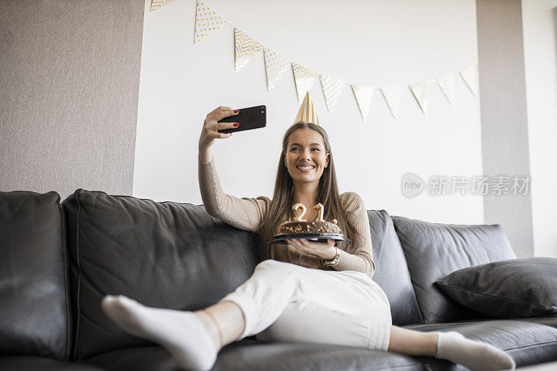 一个漂亮的女人在家里用巧克力蛋糕庆祝她21岁生日的时候视频通话