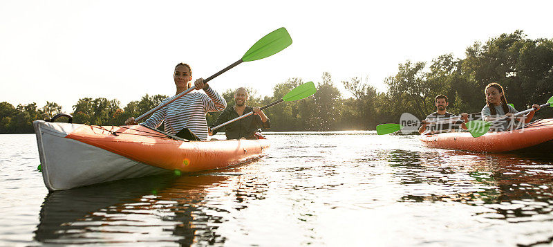 喜欢冒险的年轻人一起在河上划皮艇，在夏日的户外度过周末