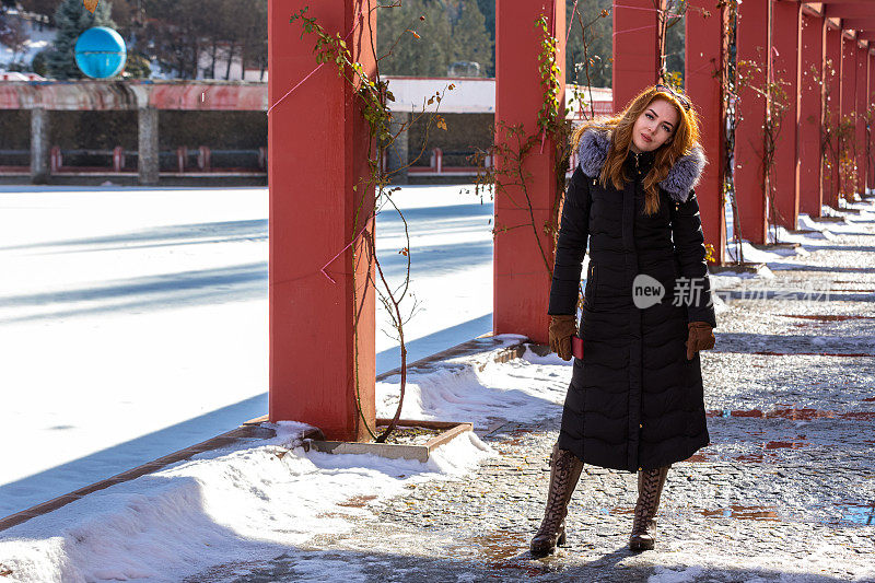 冬天和雪在公园里的红发女人