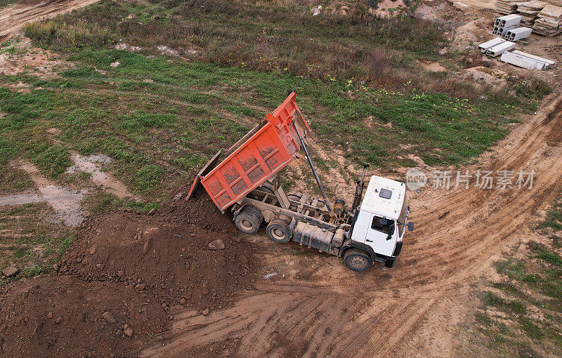 自卸车在建筑工地卸载地面和沙子。