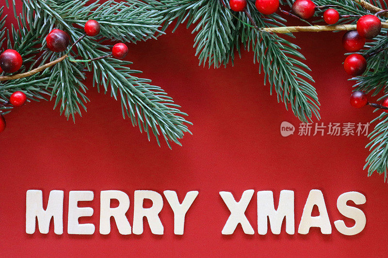 自制DIY简易圣诞卡设计的图像，在红色的背景上剪出白色的字母，云杉针和红色的浆果，手工制作的节日圣诞贺卡，圣诞快乐的信息