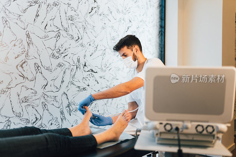 足科医生正在给病人的脚做超声波检查。
