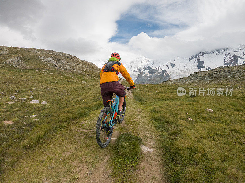 山地车的后视图在土路向冰川移动