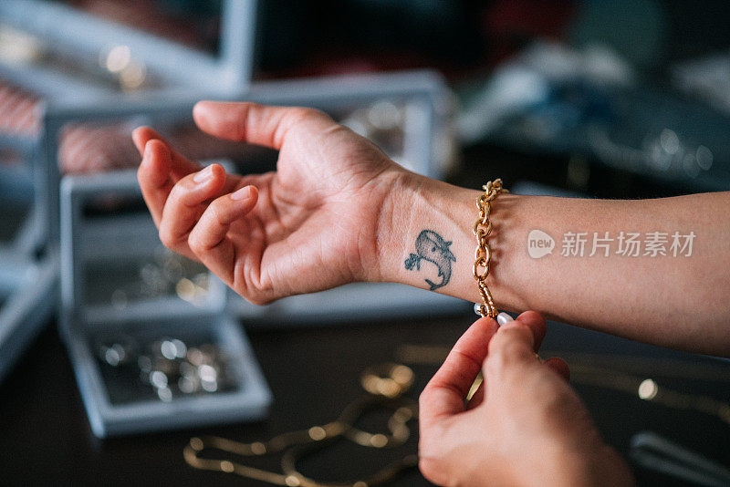 一名亚洲女性的手展示着金手镯等奢侈饰品