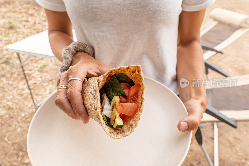 年轻女子拿着一盘素食卷