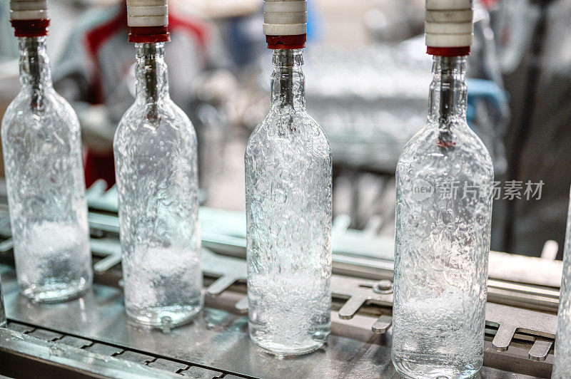 在生产线上用伏特加酒灌装玻璃瓶