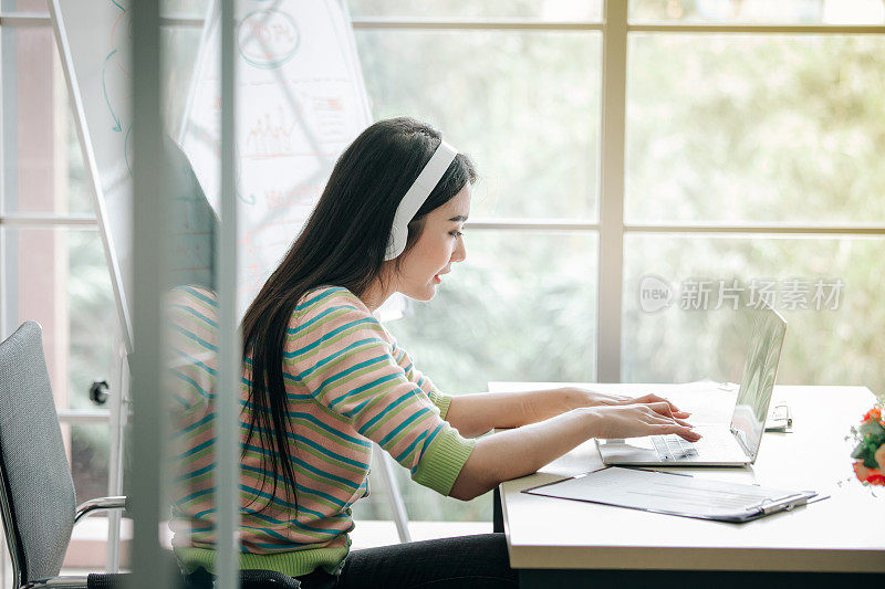 戴着耳机工作和学习的妇女