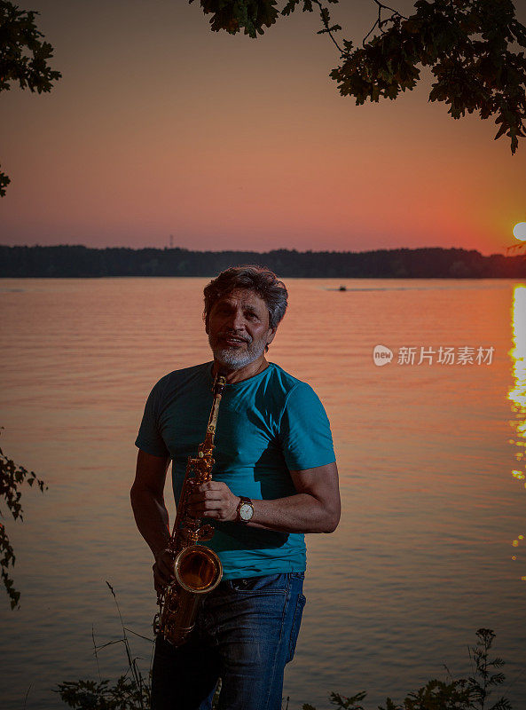 黄昏时分，一位成年男子在河边吹奏萨克斯管