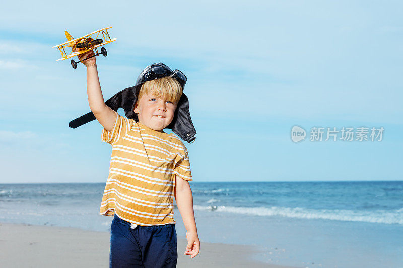 一个可爱的小男孩站在玩具模型飞机的肖像