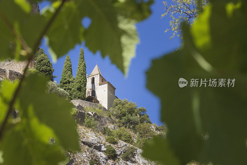 波伏娃圣母院礼拜堂和它的老洛玛巴德塔耸立在穆斯蒂埃村上方的岩石之间