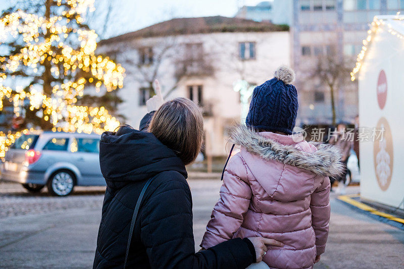 黄昏时分，母女俩走过圣诞市场