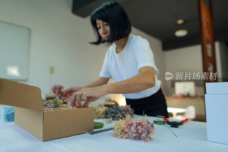 一位女花艺教师正在用绣球花制作花圈