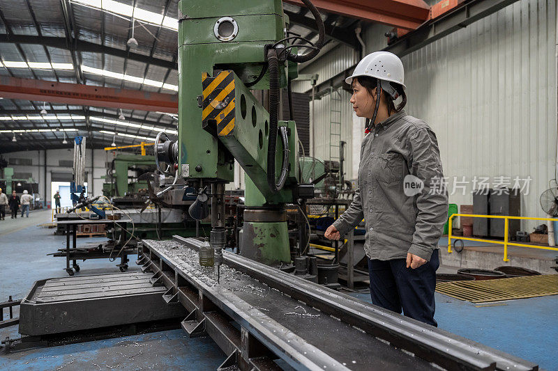 一位亚洲女工在一家机械厂工作