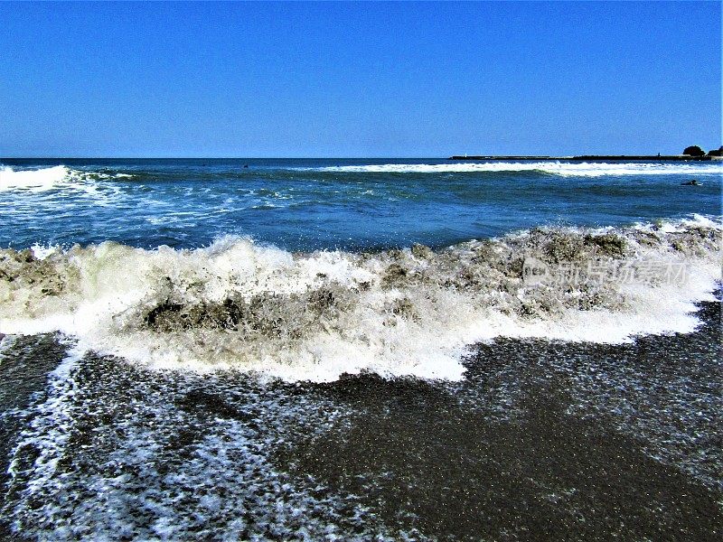日本。天气晴朗。海边的海浪和泡沫。