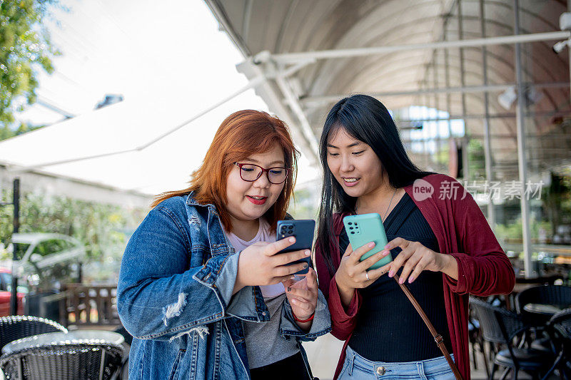 日本女性朋友在城市中使用智能手机