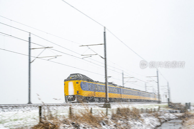 荷兰铁路公司的城际列车行驶在雪地上