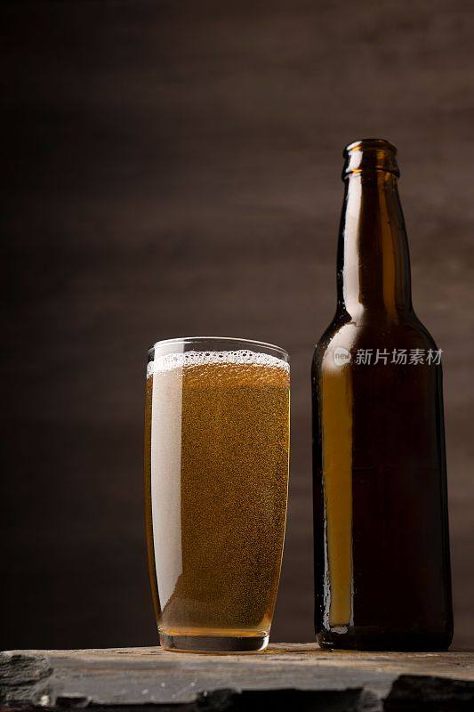砖墙旁边的桌子上放着啤酒杯和啤酒瓶