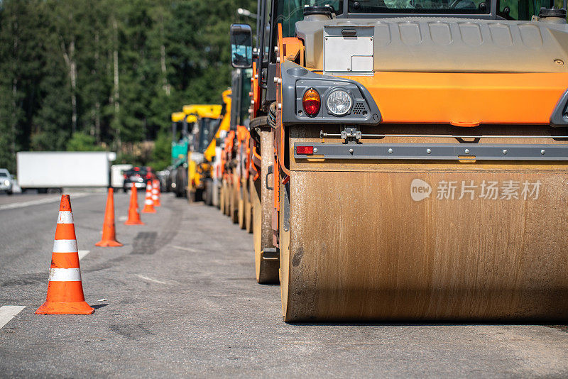 压路机停在路边，交通锥在道路的分界线上