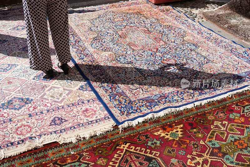 一个女人走在跳蚤市场的地毯上