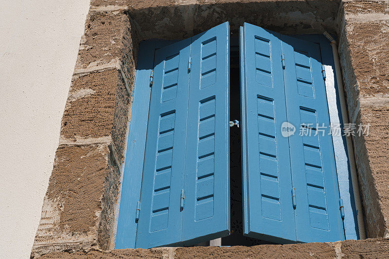 蓝色木窗穿梭在粉刷过的希腊爱琴海房产