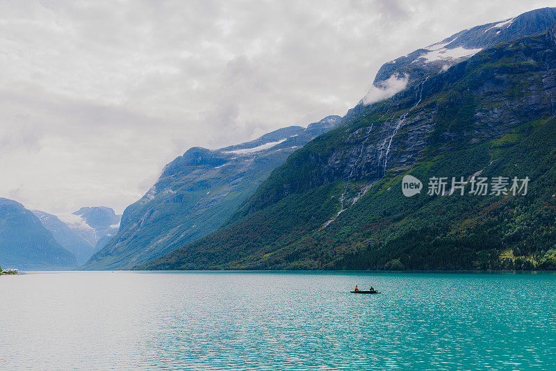 在山上的水晶蓝湖乘船的人们