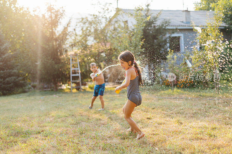 炎热的夏日，孩子们在院子里打水仗