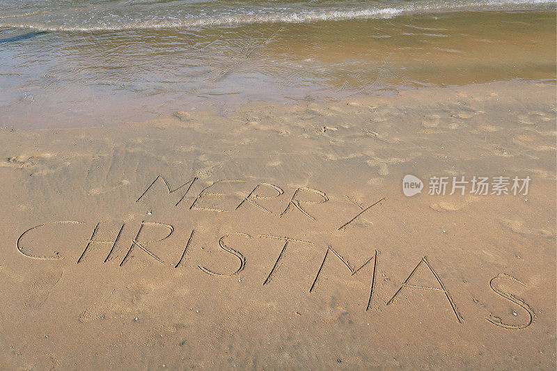 图片的标签标签写在阳光沙滩上的圣诞快乐的单词写在沙滩上，Palolem海滩，印度果阿，概念社交媒体照片的手写在金色的沙子与现代标签前缀