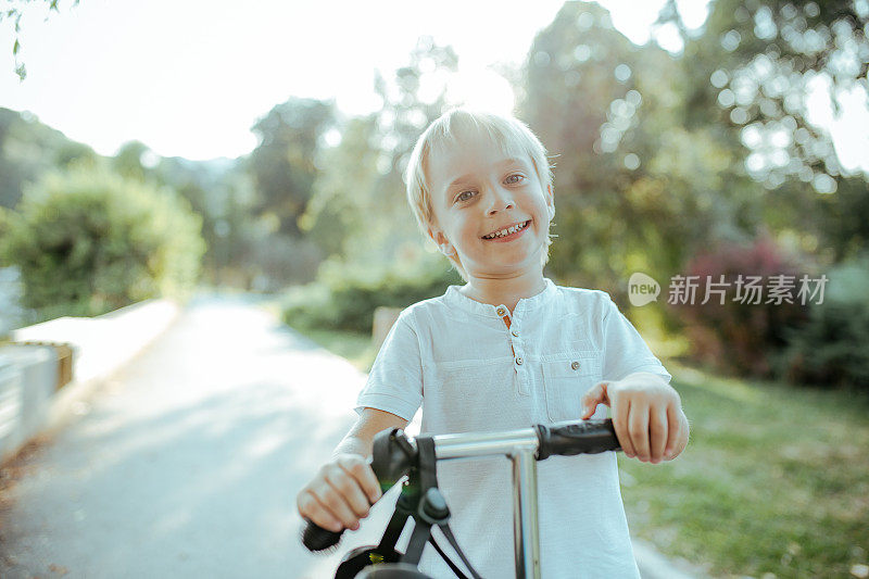 小男孩骑着滑板车