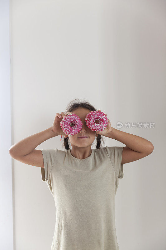 女孩拿着甜甜圈对着眼睛