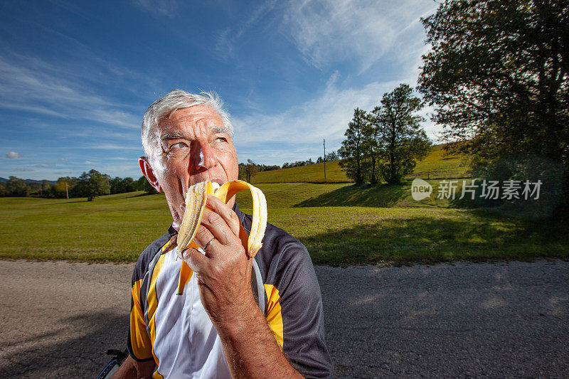骑自行车的老人在农村吃香蕉的肖像