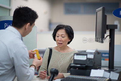 亚洲女性接受建议从男性药剂师库存照片