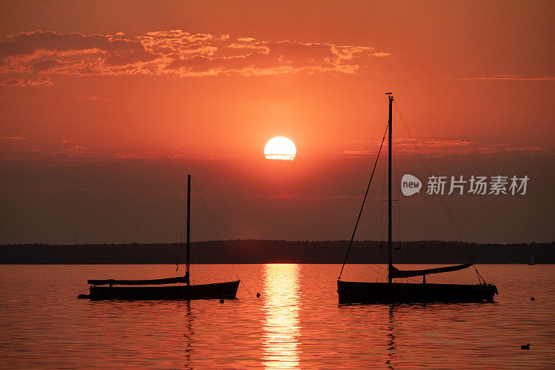 湖上的日落和小船的剪影