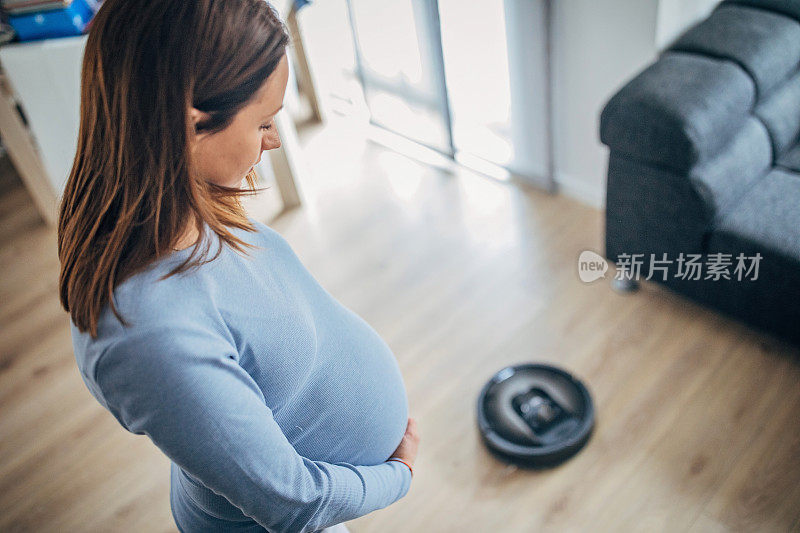 孕妇和机器人真空吸尘器