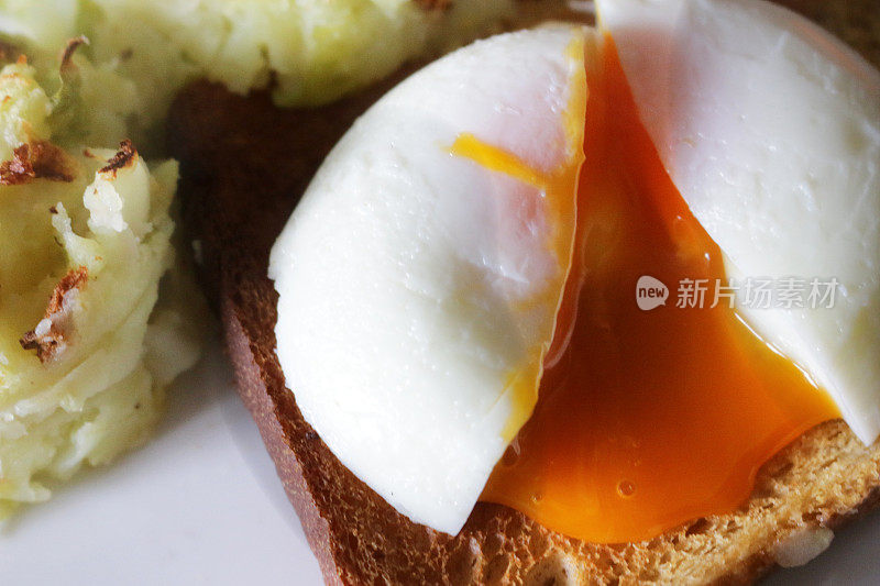 新鲜煮熟的荷包蛋配炸土豆泥，完全煮熟的鸡蛋裂开显示出流的橙色蛋黄