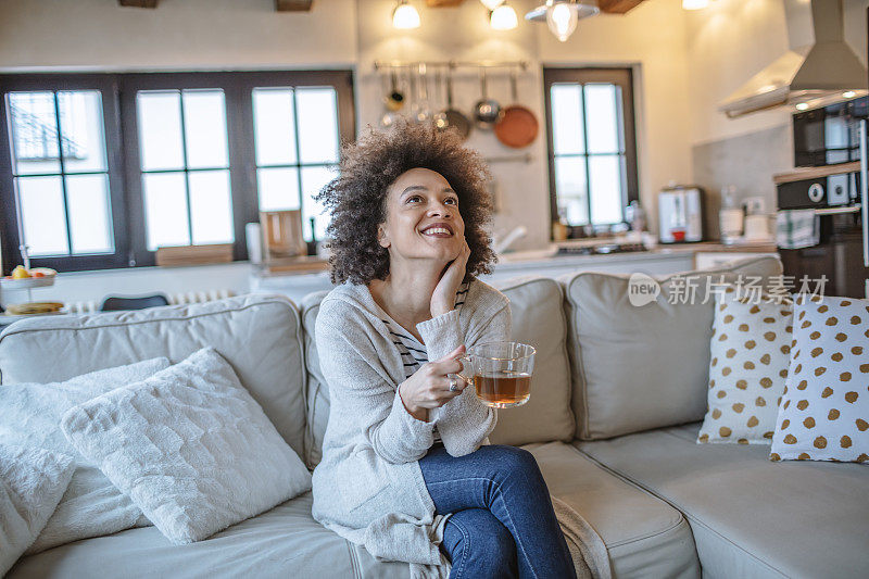 年轻的非洲裔美国妇女享受在家里喝茶的时间