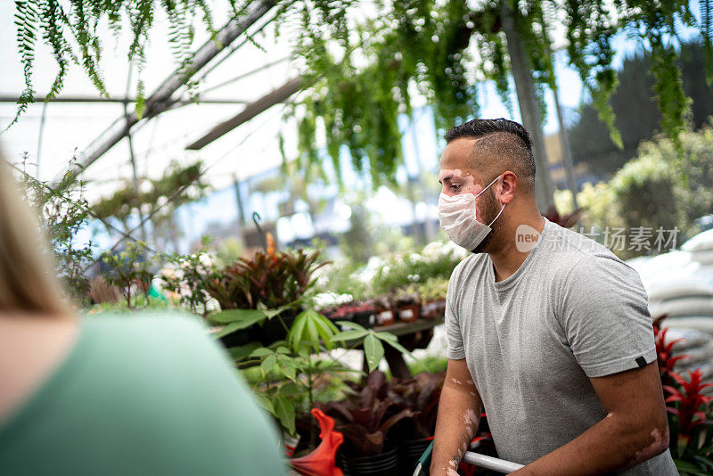 男人在花园商店买植物