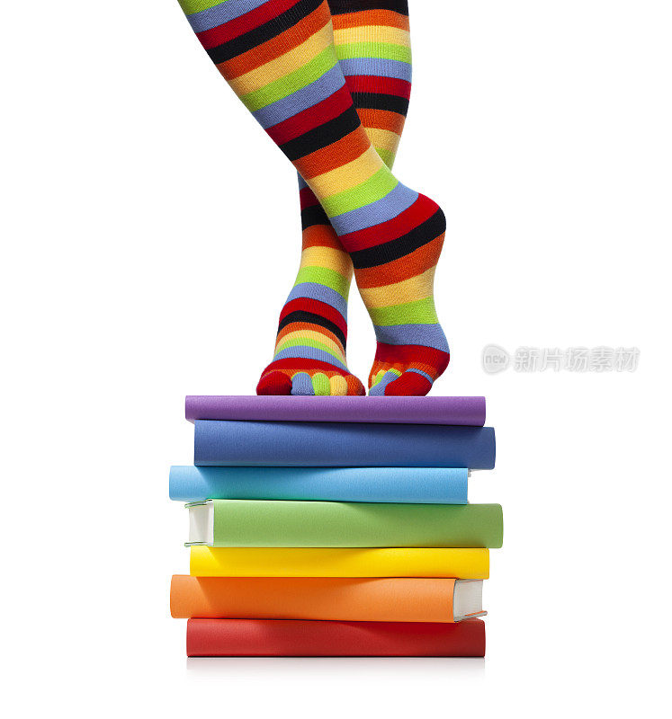 穿着彩色袜子的女人站在一堆书上