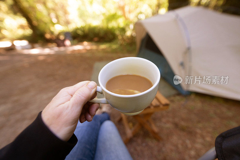 美国加州，一个女人在露营帐篷外拿着早上的咖啡