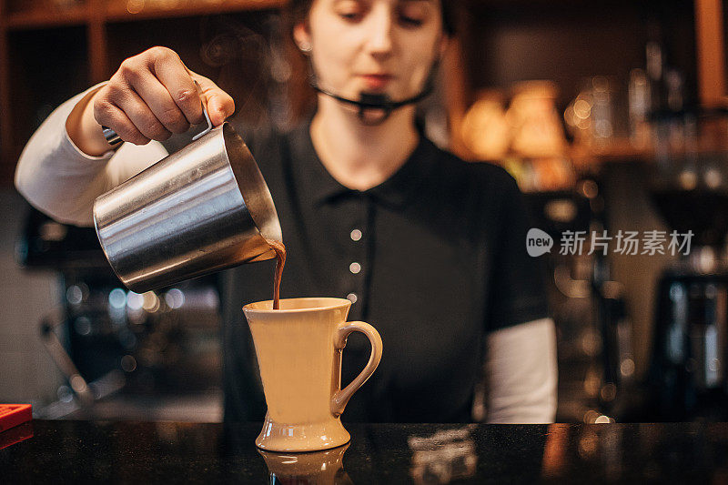 女调酒师往咖啡杯里倒咖啡