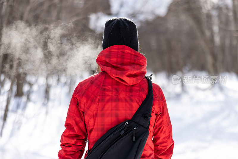 冬天穿雪鞋在森林里行走的女人