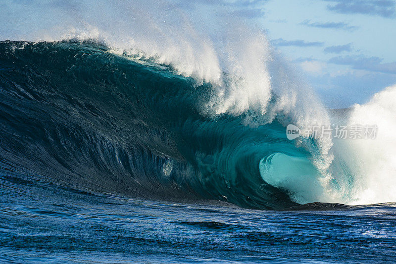 野生独特的蓝绿色波浪在岩石边缘危险地破碎