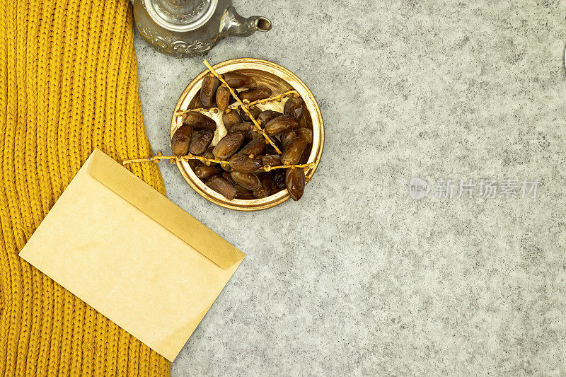 传统摩洛哥薄荷茶，银茶壶，阿拉伯饮料和成熟的枣信封模型，空白模板和冬季围巾，晒衣夹与玫瑰花