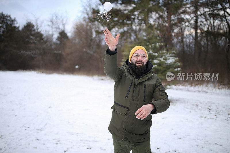 一名男子在和他的朋友们分享照片时，把雪球扔向空中