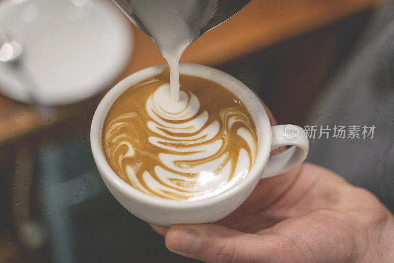 咖啡师制作咖啡杯拿铁艺术股票照片