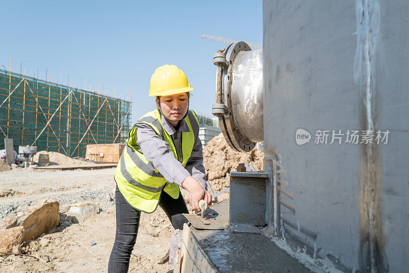 女水泥工人在工地上砌筑水泥