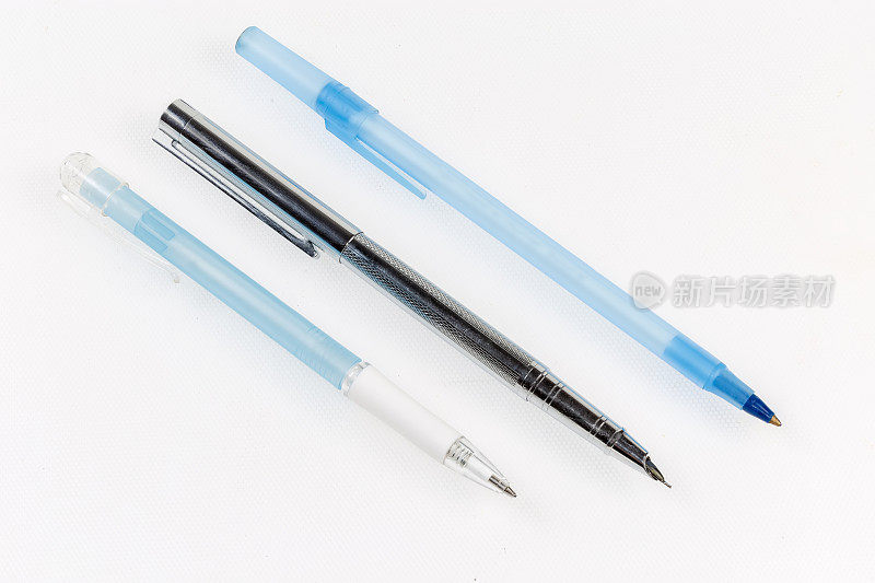 现代圆珠笔和自来水笔在浅色的表面