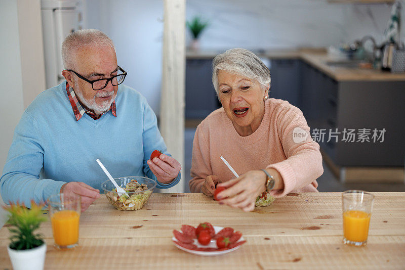 退休老年夫妇生活方式生活理念。老夫妇喜欢在厨房一起吃健康的早餐。退休夫妇的概念